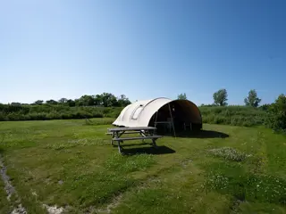 Een stoere ingerichte kampeertent nabij strand met veel privacy