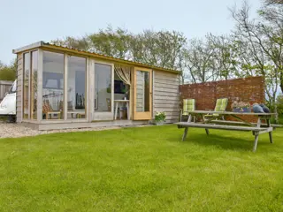 Toercaravan met houten veranda dichtbij Den Burg en De Dennen