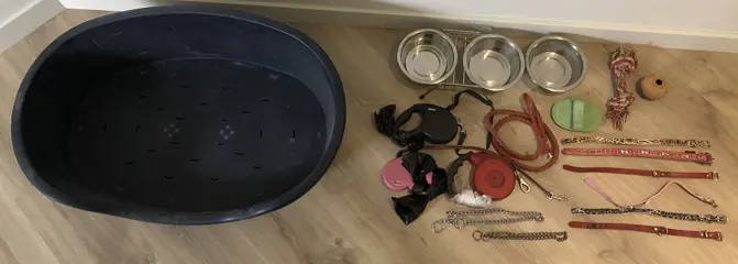 Hondenmand, 8 halsbanden, 3 hondenrollijnen, 1 vaste lijn, 3 drinkbakken, haarborstel 2 speeltjes.
