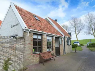 Karakteristieke oude visserswoning met uitzicht op de dijk