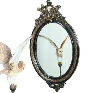 Ovale spiegel in zwart met zilver bekroond door cupido met pijlen en toorts