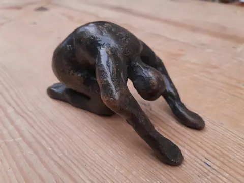 bronzen beeldje knielende figuur - buigend persoon - yoga
