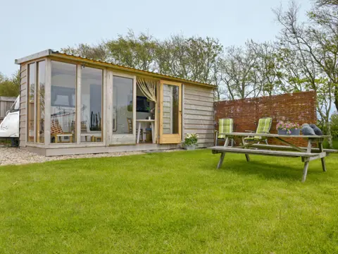 Toercaravan met houten veranda dichtbij Den Burg en De Dennen