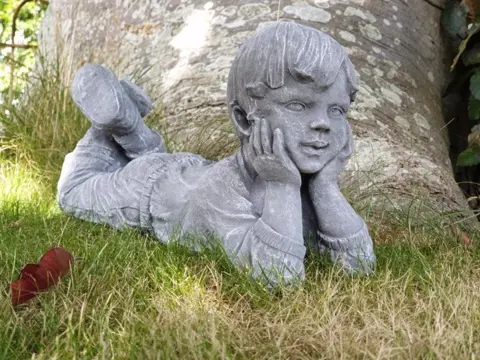 Beeld, liggende jongen, tuinbeeld