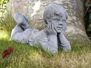 Beeld, liggende jongen, tuinbeeld