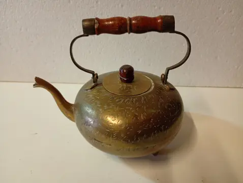 Antieke koperen theepot met houten handvat.