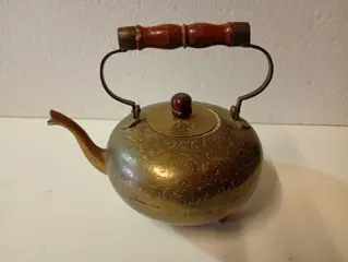 Antieke koperen theepot met houten handvat.
