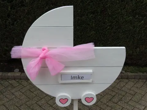 Geboorteborden / Geboortewieg met roze of blauwe versiering.