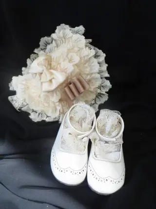 Oude brocante wit lederen schoentjes en kanten mutsje -