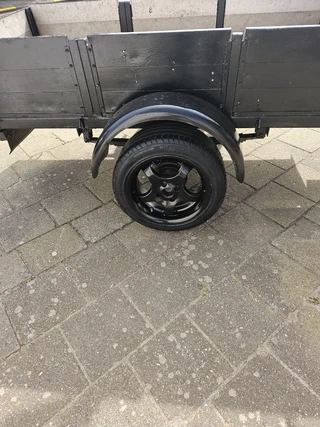aanhanger met alu zijkanten net en spanbanden en slot verlichting werkt prima
