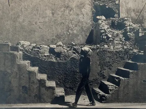 Desconicido. - Mujer paseando entre ruinas de la ciudad, La