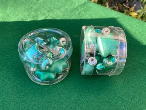 KOKER MET KLEINE KERSTBALLEN IN DE VORM VAN STERREN GROEN