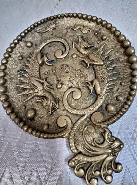 plat schoteltje met leeuwenkop en draken. (1) - Messing