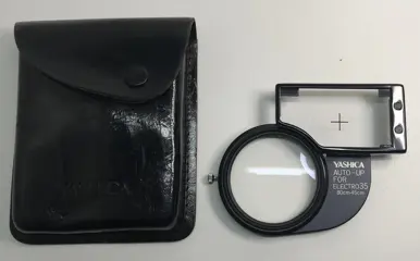 4 x Yashica items: an angle viewfinder; a viewing and taking lens no. 1; an Electro35 close-up attachment and an extension bellows 35mm SLR camera.