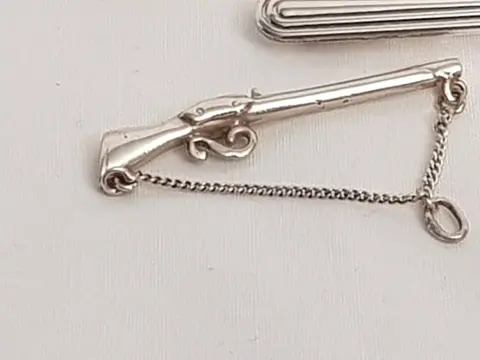 Zilveren gestreepte dasspeld. toegevoegd een dashanger in de vorm van een geweer - 835 Zilver - Dasspeld