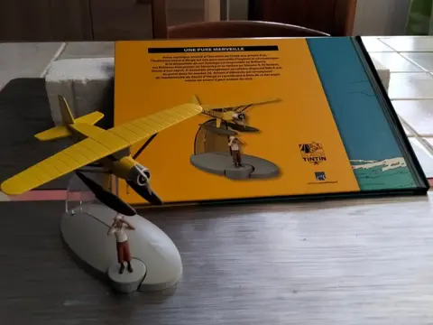 Hergé Moulinsart - 1:100 - Hydravion Tintin avec Tintin et le pied et livre explicative - Watervliegtuig van Kuifje uit het boek De krab met de gulden scharen
