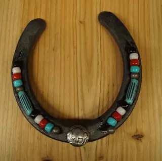 Hoefijzer met bizon op munt en kralen