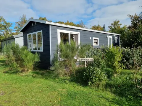 Prachtig chalet tussen de bomen en struiken van het park